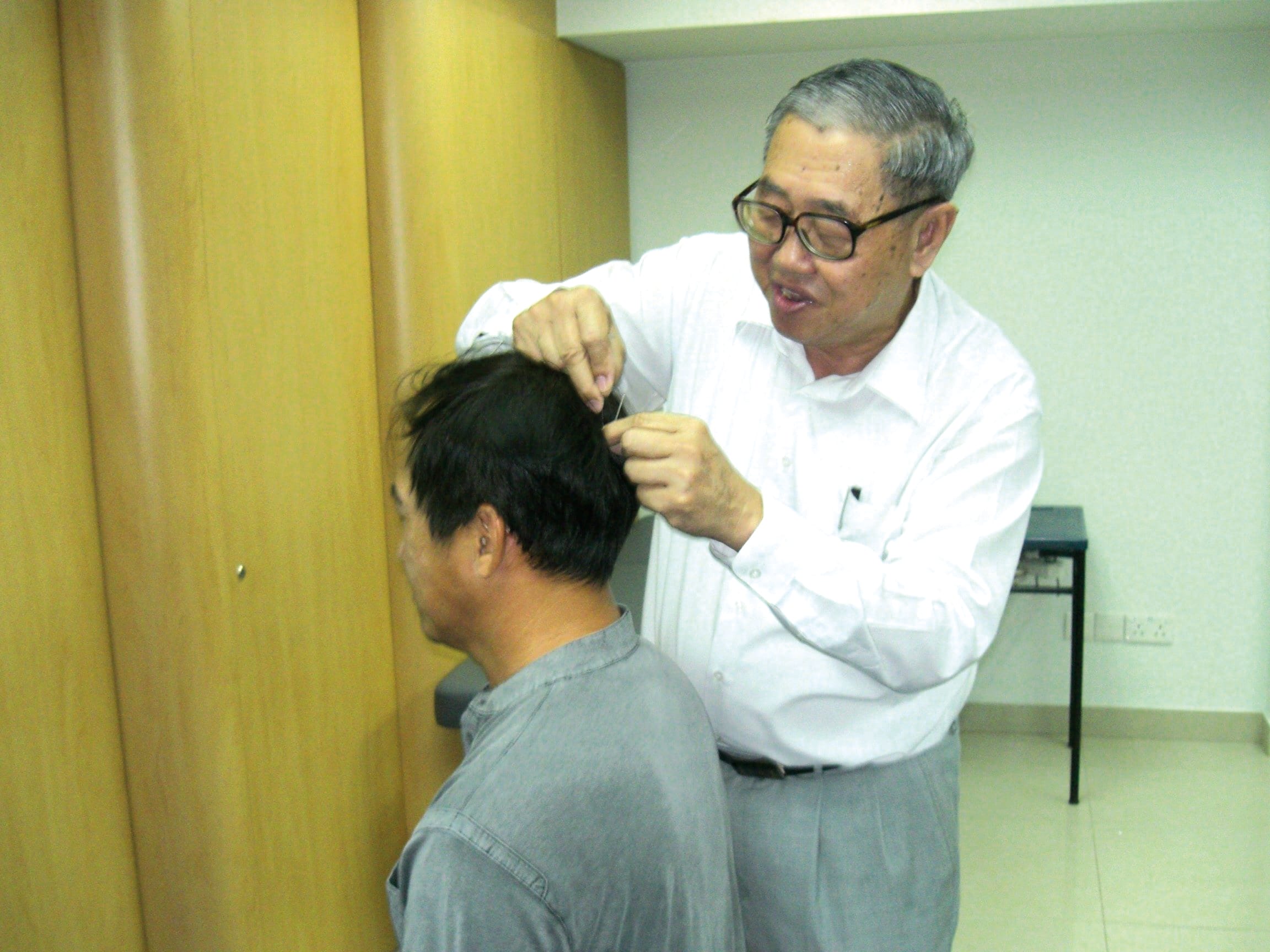 李金龙医师于2006年一次公开演讲时为观众示范针。